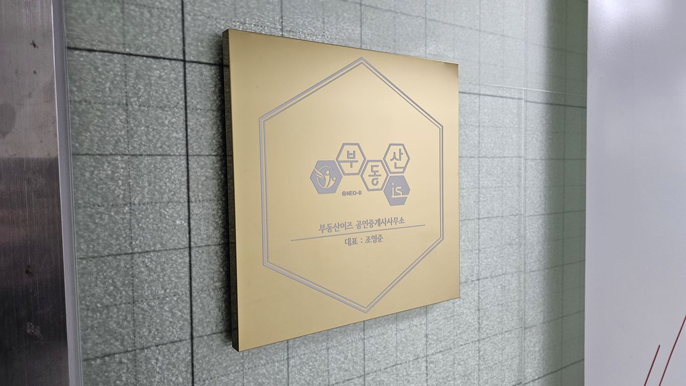 부동산이즈 로고가 새겨진 골드 현판